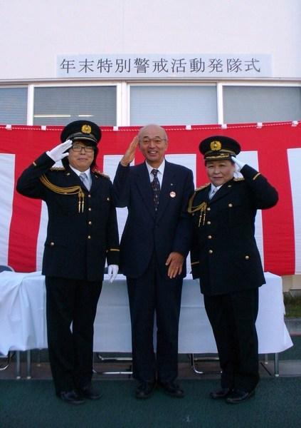 警官の制服を着た女性漫才師まるっち～ずの2名と市長が敬礼のポーズをして記念撮影している写真