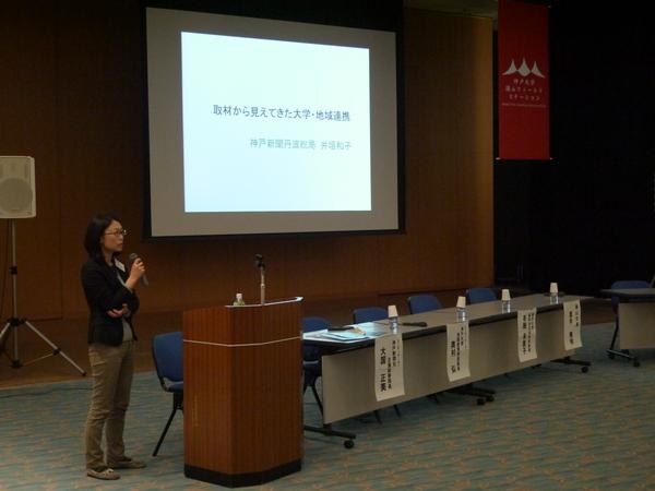 神戸新聞の井垣記者がスライドの斜め左あたりで、マイクを持ち話をしている写真