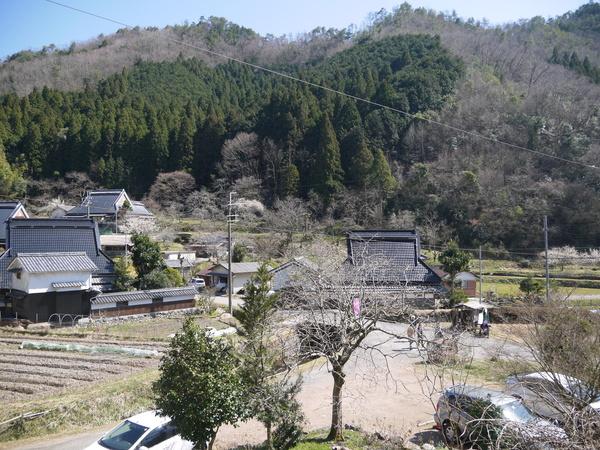 奥には山が広がり10件ほどの家屋がある集落丸山の写真