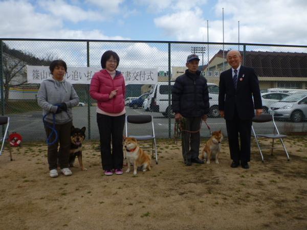 フェンスの前で市長と犬を連れた2名の女性と1名の男性が並んでいる写真