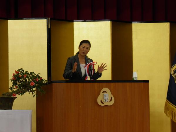 金屏風の前で、テニスの沢松さんが記念講演をしている様子の写真