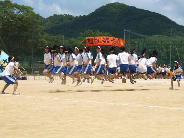 長縄跳びの競技で女子生徒が一斉に飛んでいる写真