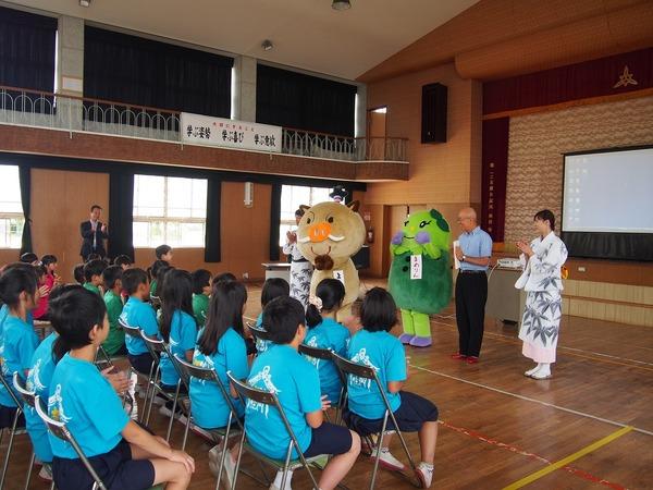 マスコット人形と踊りを踊られる方が市長と前に立ち子供達にお話ししている写真