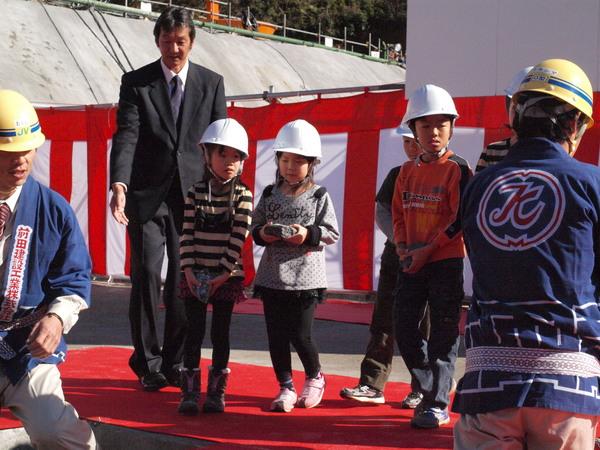 ヘルメットをかぶった女の子2人と男の子2人が夢が書かれた石を持っている様子の写真