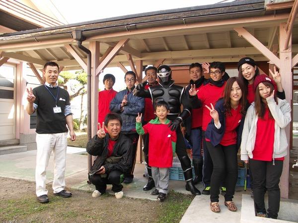 ヒーロー「ササグロー」と一緒に参加者11名とピースサインで記念撮影