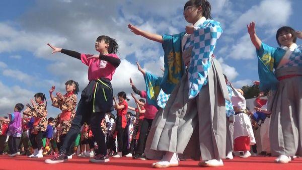 舞台上で、両手を左斜めにあげて、左足を一歩前に出している出演者たちを下からとっている写真