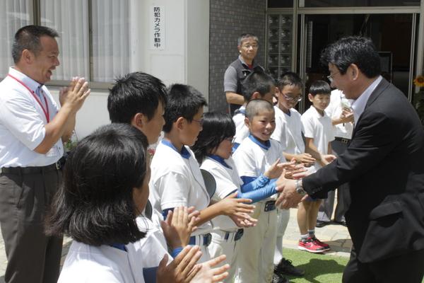 佐藤町長と野球のユニフォームを着ている子ども達が握手をしている様子の写真