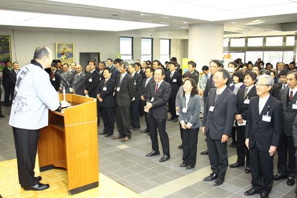 足立議長が丹波篠山の半纏を着て壇上に立ち、職員のみなさまに笑いをとりながら楽しい話をしている様子の写真