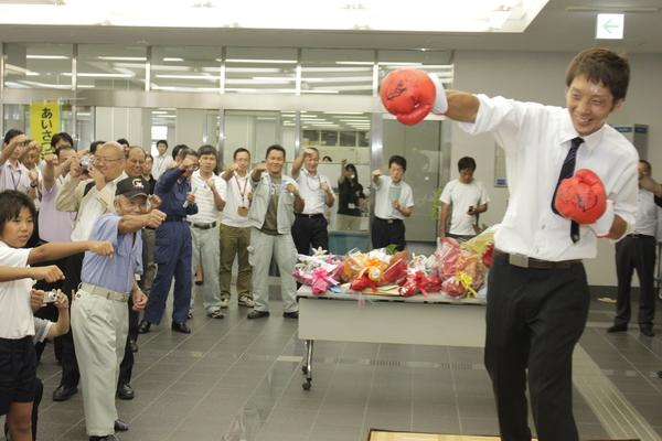 グローブをつけて、パンチのフォームをする角谷 淳志選手と参加者が同じポーズをしている写真