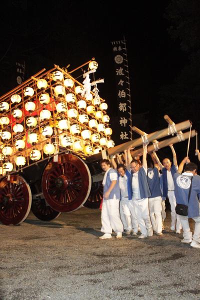 提灯を灯した山車を担いでいた男性陣が両手を挙げて持ち上げている写真