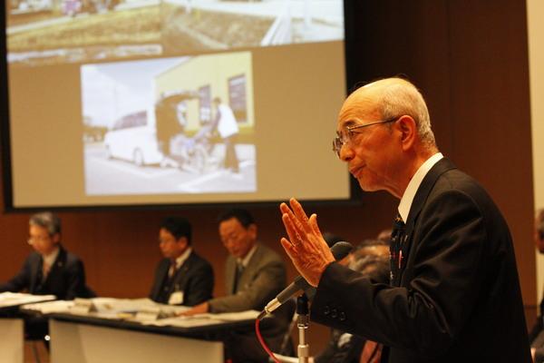 市長が手を上げ、マイクで話をしている写真