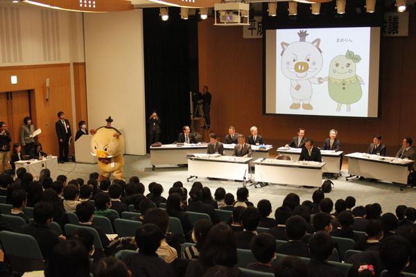 スクリーンには「まるいの」と「まめりん」が映っていて会議を後方から見た写真