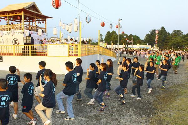 服の背中に「城東」と書かれたティシャッを着て子供や大人が踊っている写真