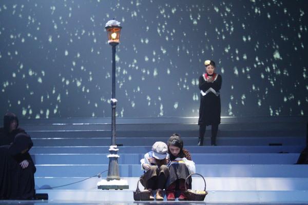 スクリーンは雪をイメージしていてその中に男の子と女の子が身を寄せ合って座っている写真