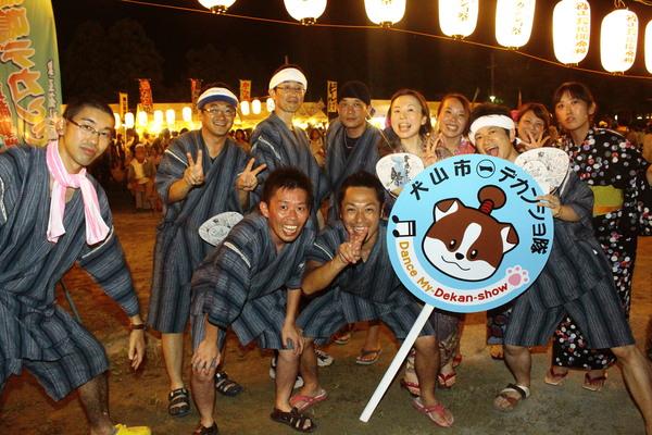 犬山市、デカンショ隊と書かれたプラカードを男性が支えて犬山市職員で記念撮影写真