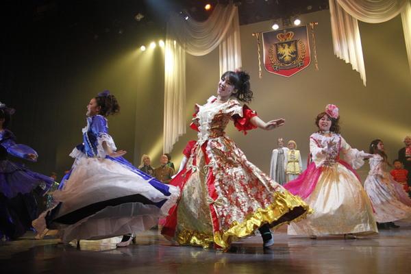 女性達が色鮮やかなドレスで楽しく踊りながら歌っている写真