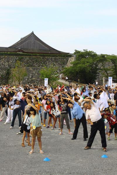 体を横に曲げる運動をする老若男女の写真