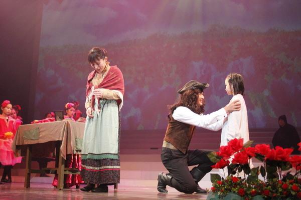 男性が1人の女の子と同じ目線で座り込んで話しかけその隣では女性が泣いている写真