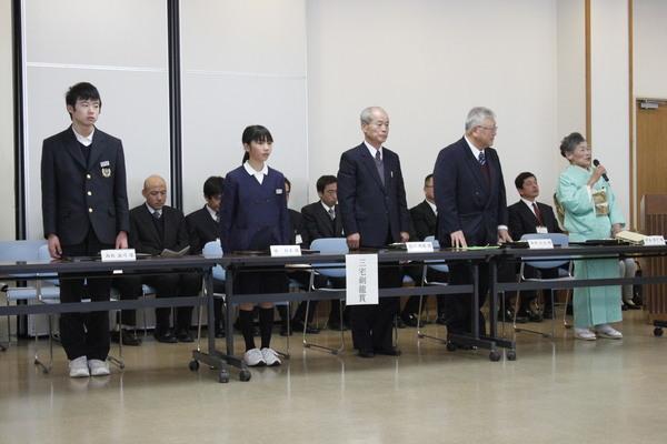 三宅剣龍賞と書かれた机の前に立っている男女学生とスーツを着た男性2名、着物を着てマイクを持ってお話をしている女性の写真