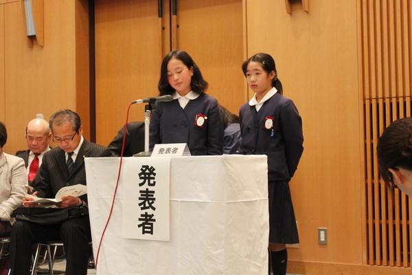 制服を着た小学生が発表している写真