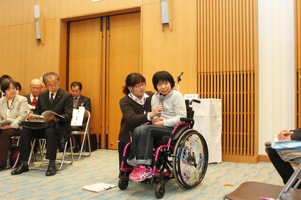 先生が車いすの小学生にマイクを向けている写真