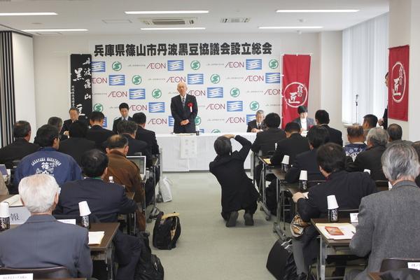 黒豆協議会設立総会にて、関係者が座り、市長が挨拶をしている写真