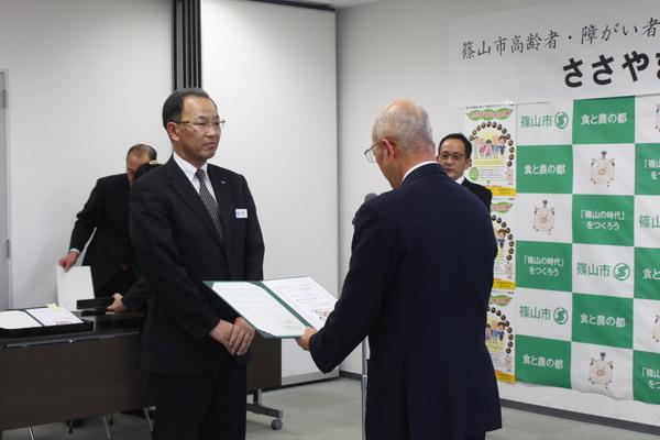 両手を前で添えている隊員の方に証書を読み上げている市長の写真