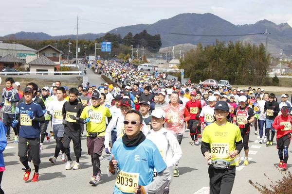 山に囲まれのどかな風景の中、沢山の選手が一生懸命走っている写真