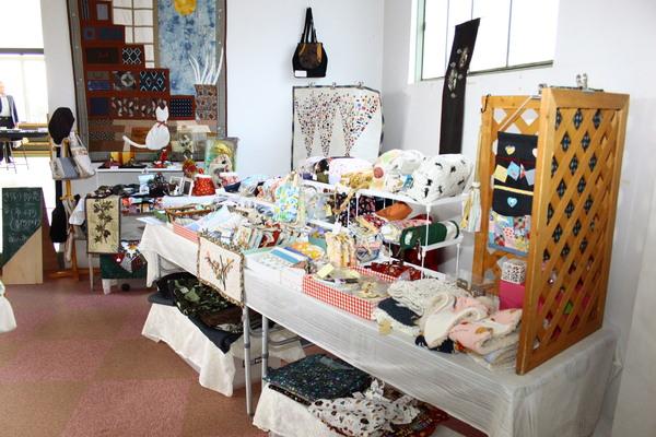 手作りの作品が置かれているコーナーが設けられており、パッチワークやボーチなどの作品が並べられている写真