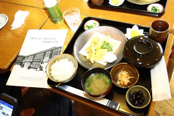 お膳に出されている、ご飯、みそ汁、てんぷら、黒豆などの定食の写真