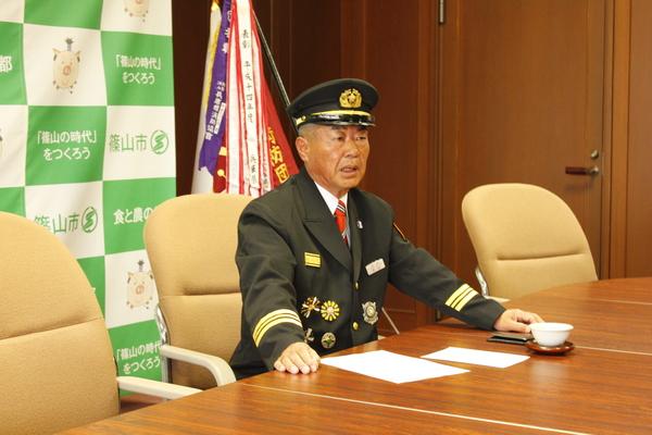市長室で北山正さんが消防団の礼服をきて就任あいさつをしている写真