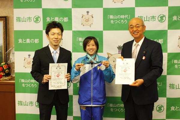銀メダルを2つつける井上 真帆さんと、その両隣で賞状を持つ市長と男性の写真
