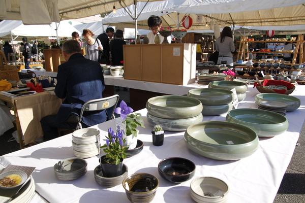 白いテーブルクロスの上に小さい皿や大きい皿の丹波焼が飾られている写真