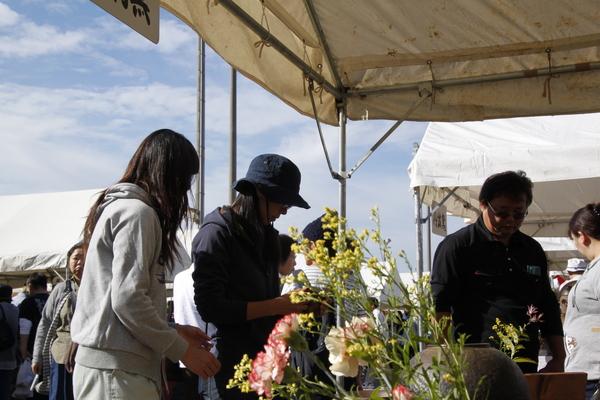 テントの中で女性2人と男性が丹波焼を見に来ている写真
