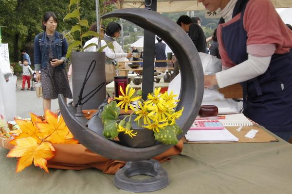 三日月のような形をした置物の中に黄色い花が飾られている写真