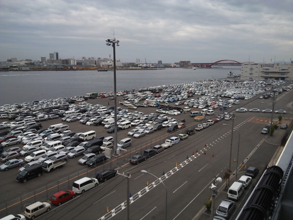 奥には川が流れていて、その手前に沢山の車が停めてある空撮写真