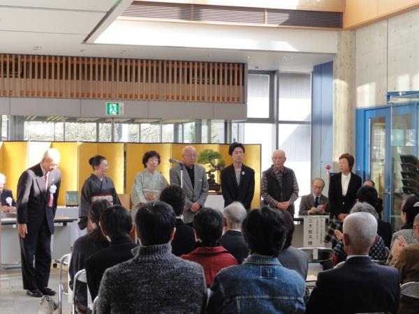 市長と受賞者のみなさんが前に立ち、その様子を椅子に座っている方々が見ている写真