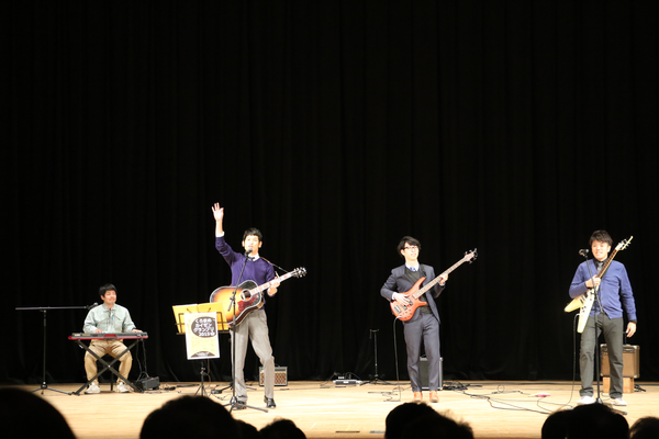 オープニング発表でキーボードの男性1名、ギターの男性3名が演奏している写真