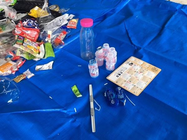 バインダーの留め具、修正テープの容器、プラスチックのボトル、ヤクルトの容器など容器包装プラスチック以外の物が集められた写真