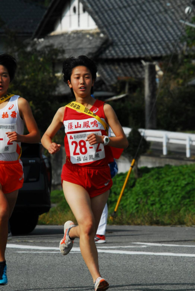 白色に赤のラインが入ったランニングシューズを履いて走っている細見 清花選手の写真