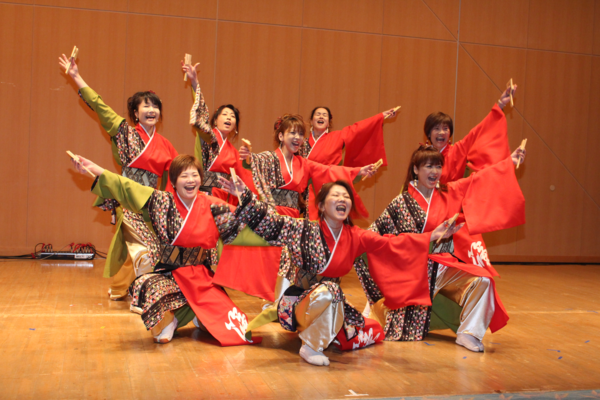 女性のグループがよさこいを踊って最後に声を出してポーズを決めている様子の写真