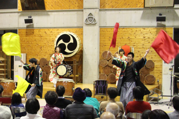 和太鼓・篠笛ユニットの演奏が盛り上がり、よさこいグループ「丹波篠山楽空間」のメンバーも旗を振って踊りで加わり盛り上がっている様子の写真