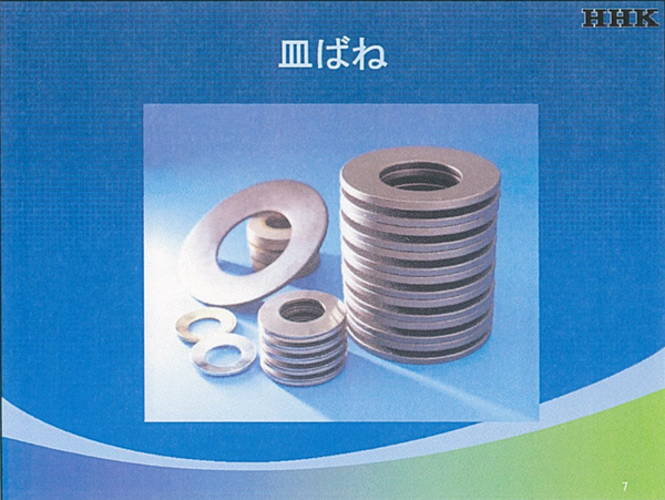 中心に穴のある円板を円錐状に加工して底のない形状を大小にして置いた主力商品「皿ばね」の写真
