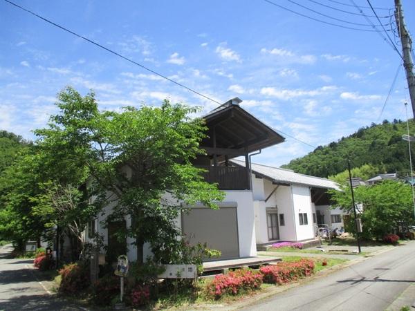 こしお団地の角にある白い建物が緑に囲まれている写真