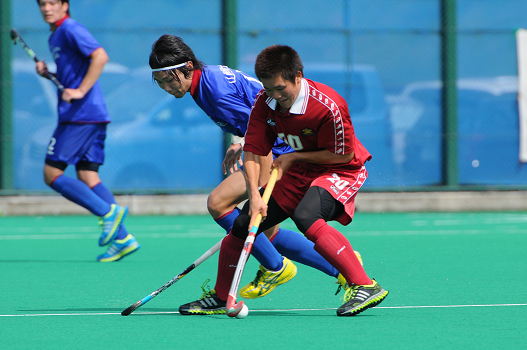 赤いユニフォームをきた河野君がホッケーをしている写真