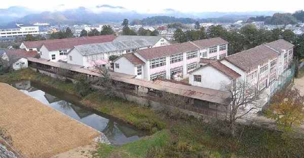 切妻屋根をした5棟の校舎が並んでいる篠山小学を少し離れた高い場所から撮られている写真