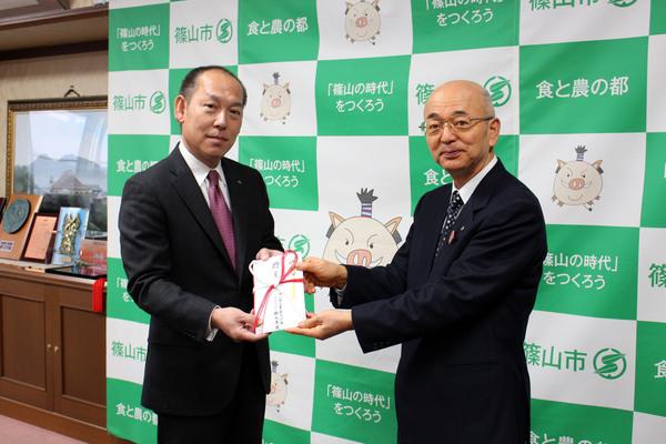 フルヤ工業株式会社、代表取締役の降矢寿民さんから市長へご寄付を渡している写真