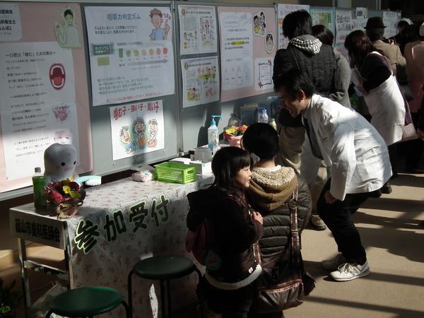 篠山市食育推進大会にて受付をしている母親と横にいる女の子の写真