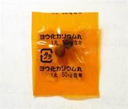 オレンジ色の半透明の小袋に入っている2錠のヨウ化カリウム丸の写真