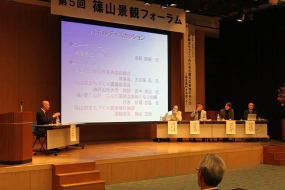 舞台上で左からコーディネーターの田原 直樹氏、パネリストの大久保 弘氏、杉尾 吉弘氏、田中 栄治氏、横山 宜致がパネルディスカッションをしている写真